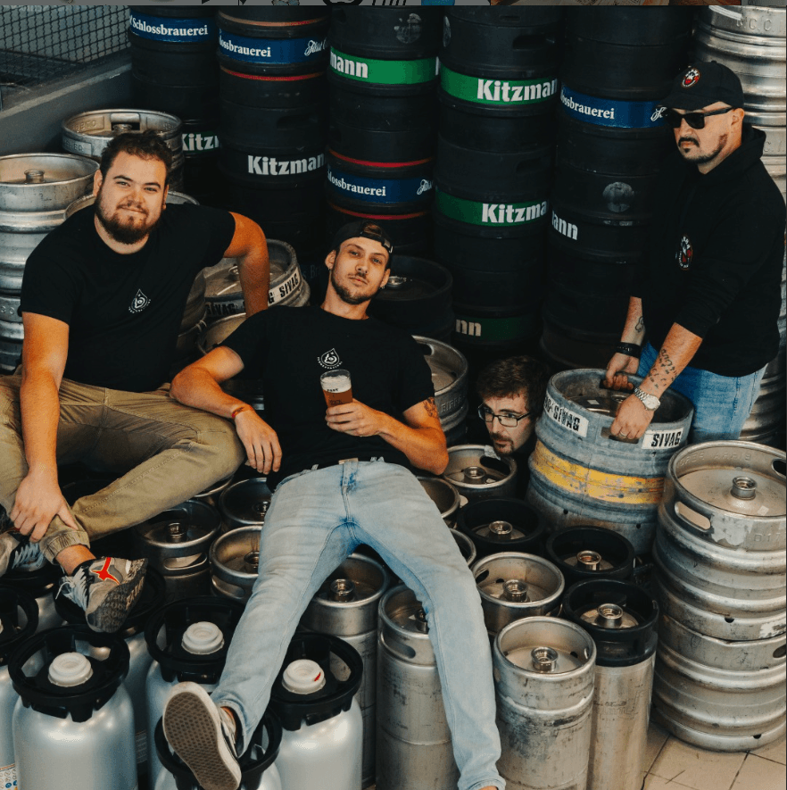 Team di De Lab Fermentazioni tra i fusti di birra artigianale