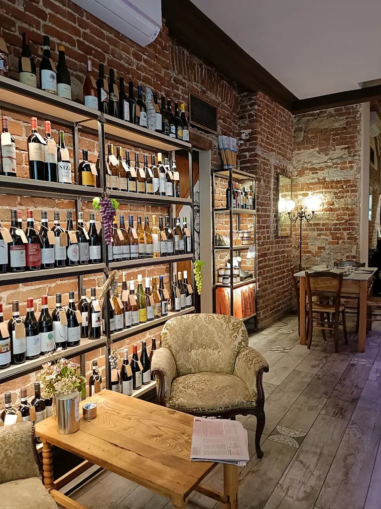 Sala con mattoni a vista e scaffale vini di Gastropasticceria Scaiola